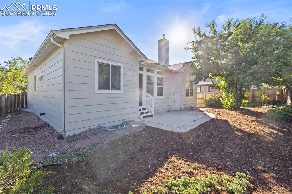 Image 37 of 39: Out back, a fenced yard with a patio and private gate creates the perfect c