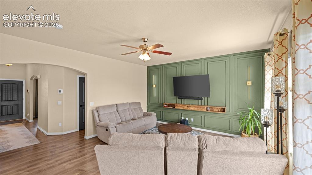 Image 11 of 41: Living room with a feature wall showcasing vertical paneling, integrated sc