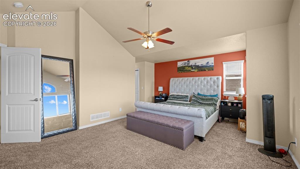 Image 15 of 41: Vaulted ceiling with an arched window, ceiling fan, and carpeted flooring