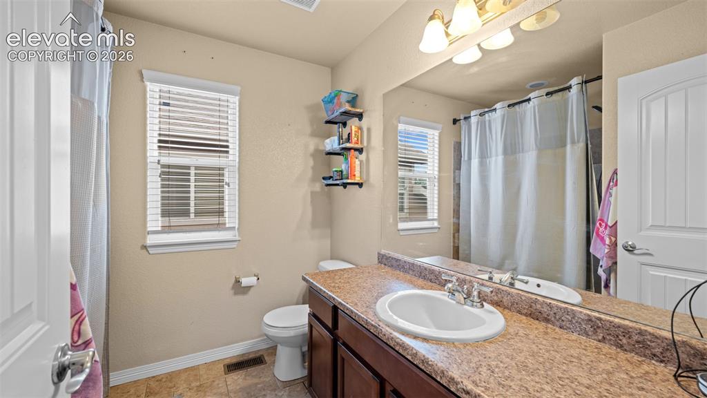 Image 19 of 41: Bedroom featuring light beige wall color, textured carpeting, a window with