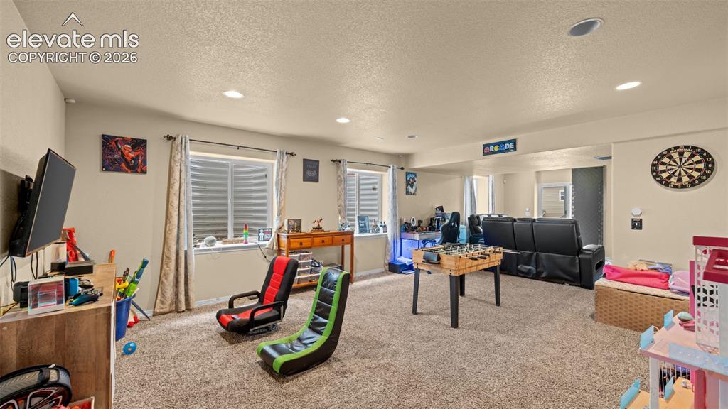 Image 27 of 41: Spacious carpeted room featuring recessed lighting, multiple windows with b