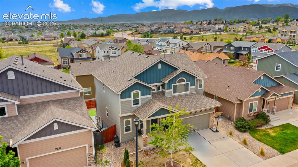 Image 30 of 41: Multi-story residence featuring a three-car tandem garage, pitched roof, an