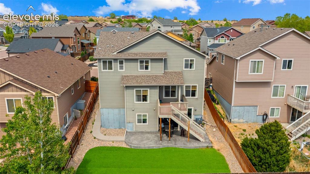 Image 32 of 41: Rear elevation with a deck and stairs leading to a stamped concrete patio