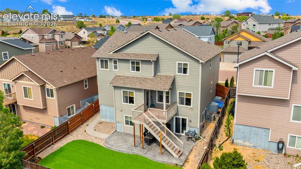 Image 33 of 41: Two-story home featuring a ground-level patio with an upper-level deck, a f