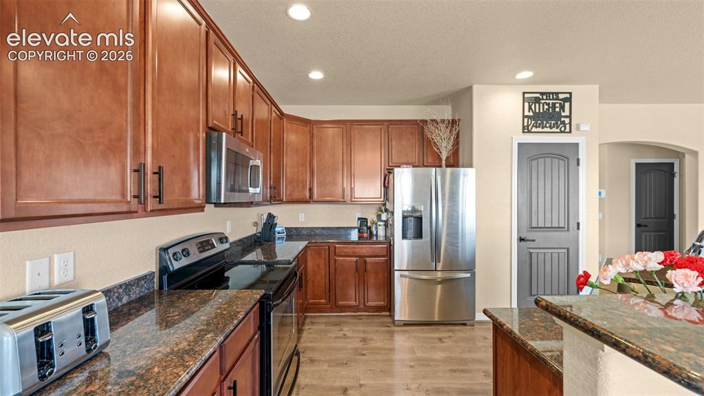 Image 8 of 41: Kitchen featuring a large island with sink, wood-finish flooring, stainless