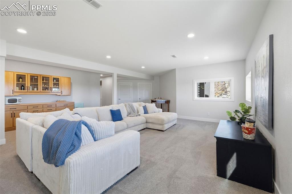 Image 40 of 50: Basement Rec Room with Dry Bar