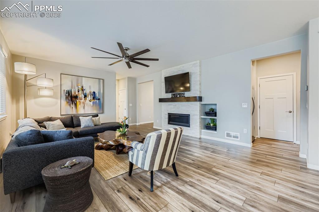 Image 10 of 50: Living room featuring a large fireplace and light wood-type flooring