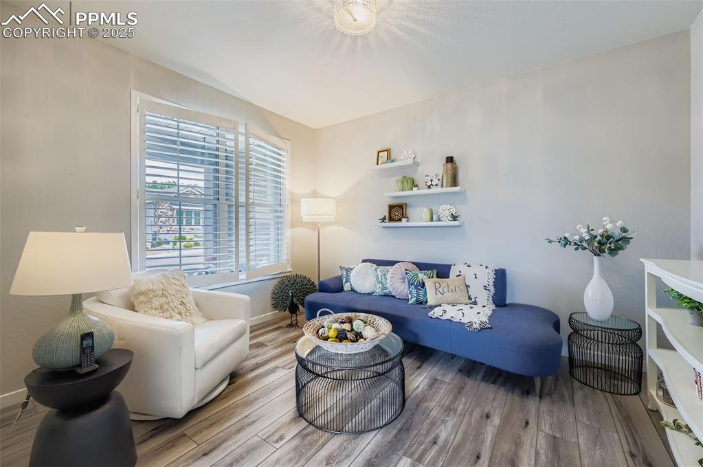 Image 11 of 50: Living area featuring wood finished floors and baseboards