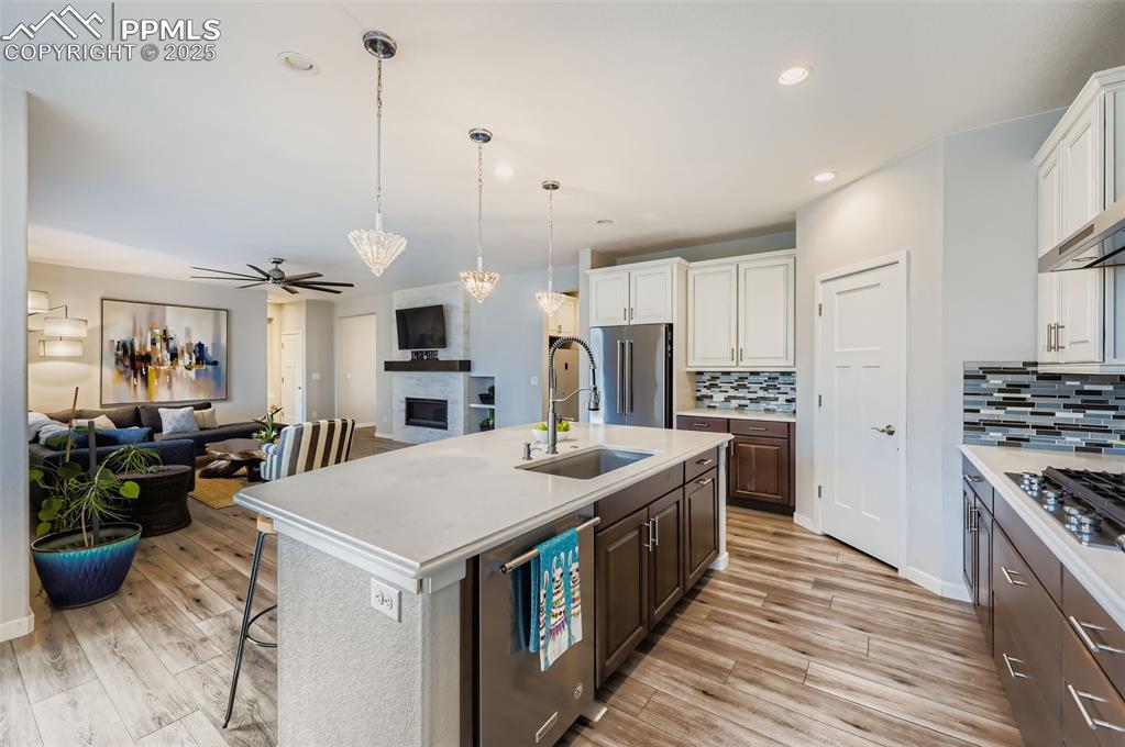 Image 13 of 50: Kitchen with pendant lighting, a breakfast bar, open floor plan, dark brown