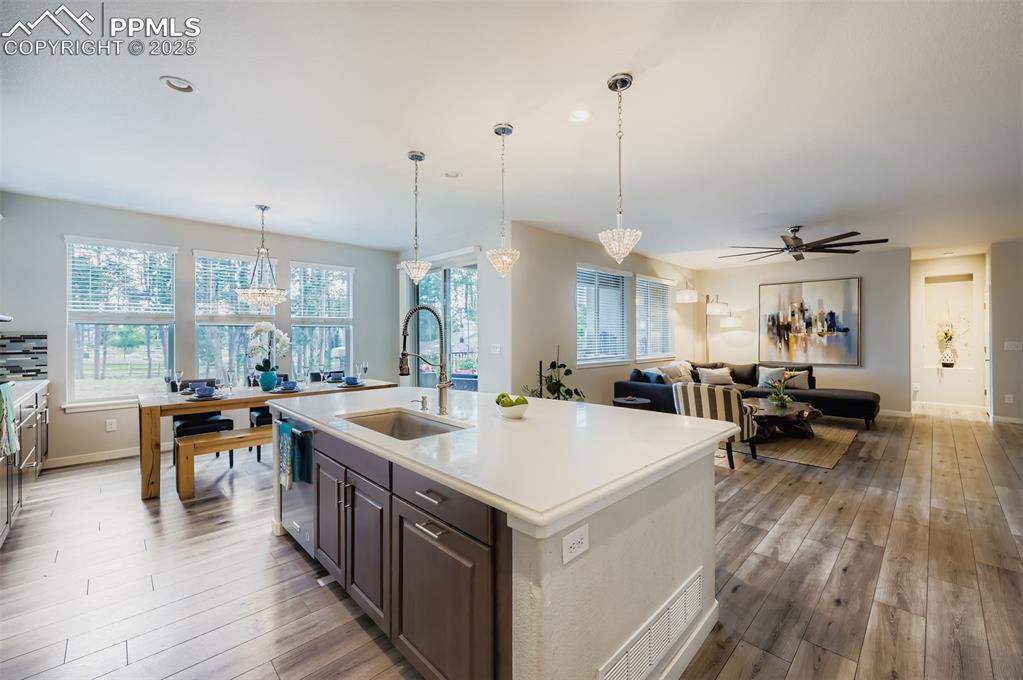 Image 16 of 50: Kitchen featuring hanging light fixtures, a center island with sink, a ceil