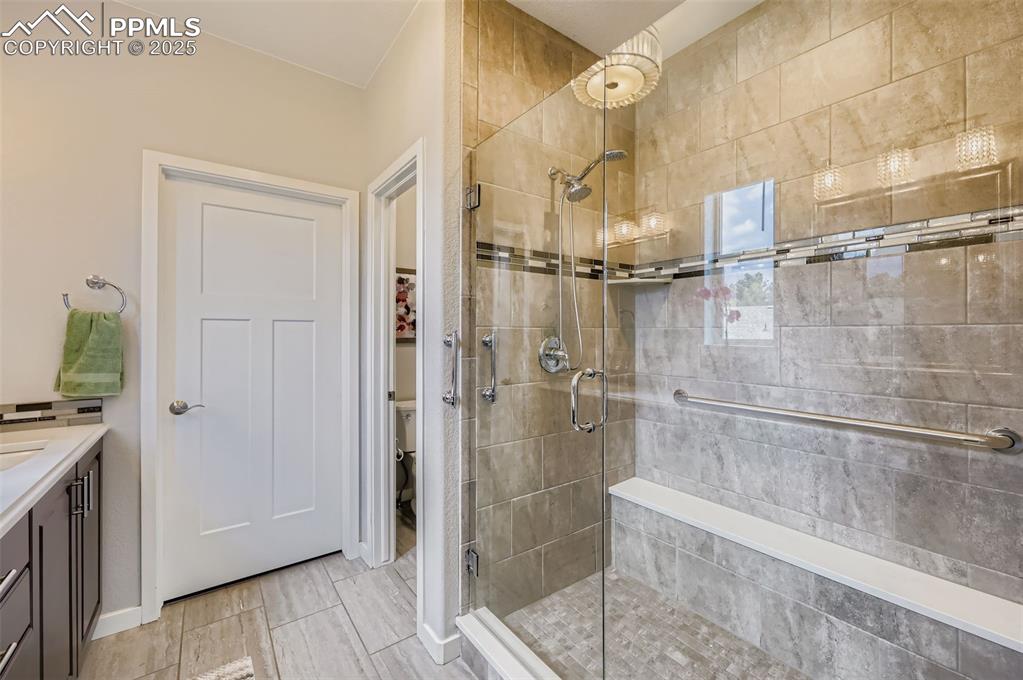 Image 24 of 50: Bathroom featuring vanity, a stall shower, and wood tiled floors