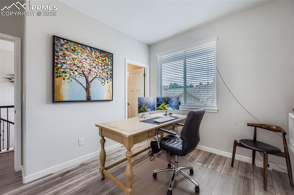 Image 26 of 50: Office space with light wood-type flooring and baseboards