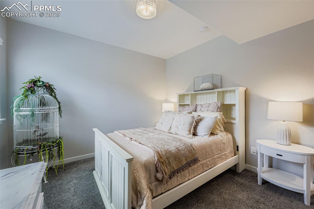 Image 34 of 50: Bedroom featuring dark colored carpet and baseboards