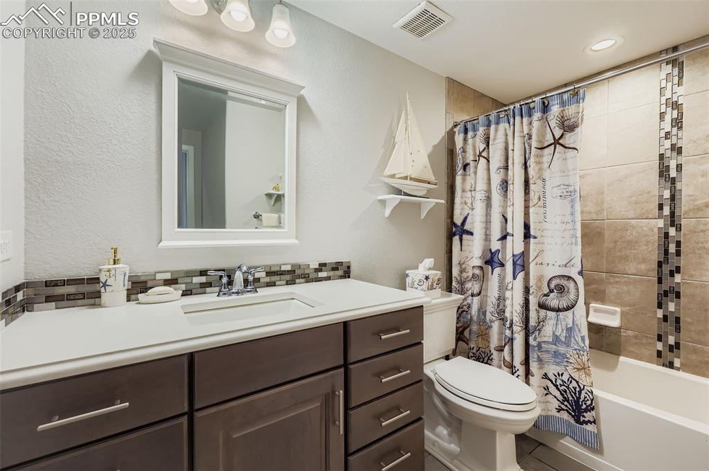 Image 38 of 50: Bathroom featuring shower / bath combination with curtain, vanity, a textur