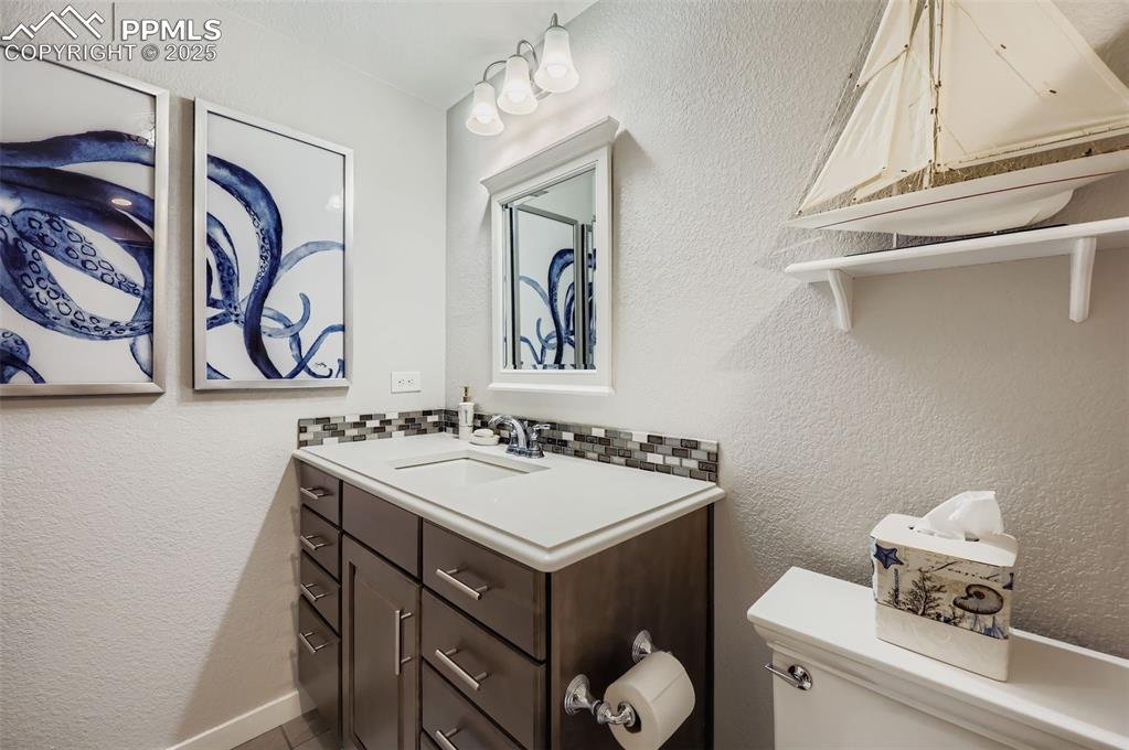 Image 39 of 50: Half bathroom with a textured wall and vanity