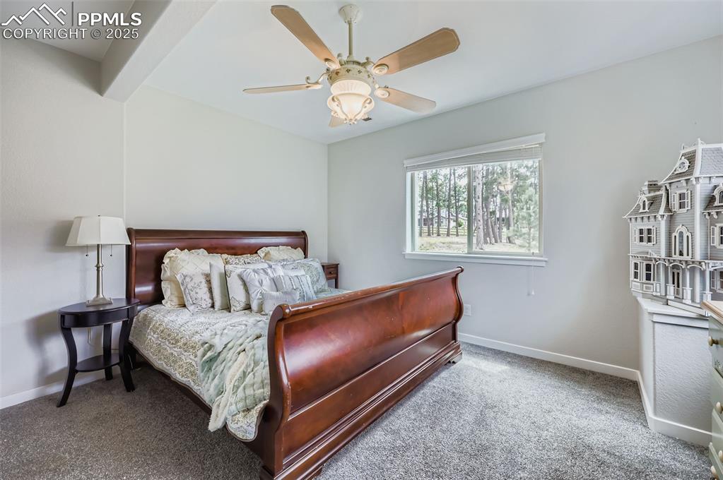Image 41 of 50: Carpeted bedroom with baseboards and ceiling fan