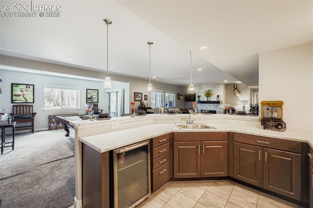 Image 45 of 50: Kitchen featuring open floor plan, wine cooler, healthy amount of natural l