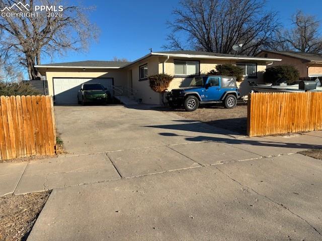 Caption: View of property exterior with driveway, stucco siding, and an attached garage