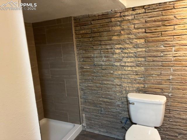 Image 18 of 24: Bathroom with toilet and a stall shower