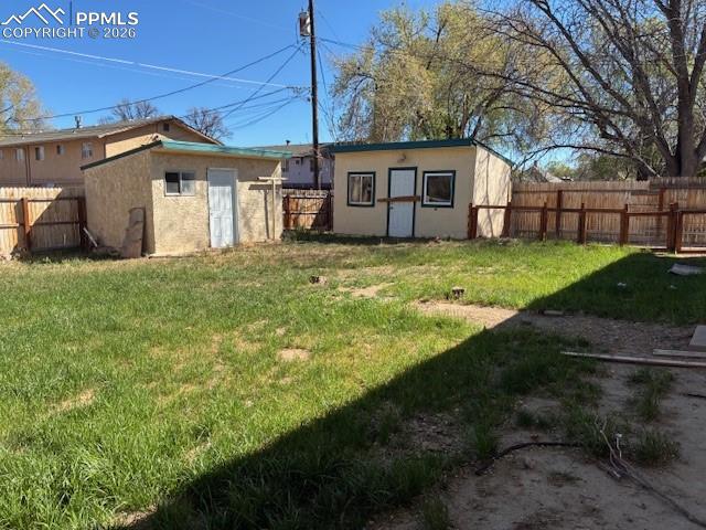 Image 22 of 24: Fenced backyard featuring an outbuilding