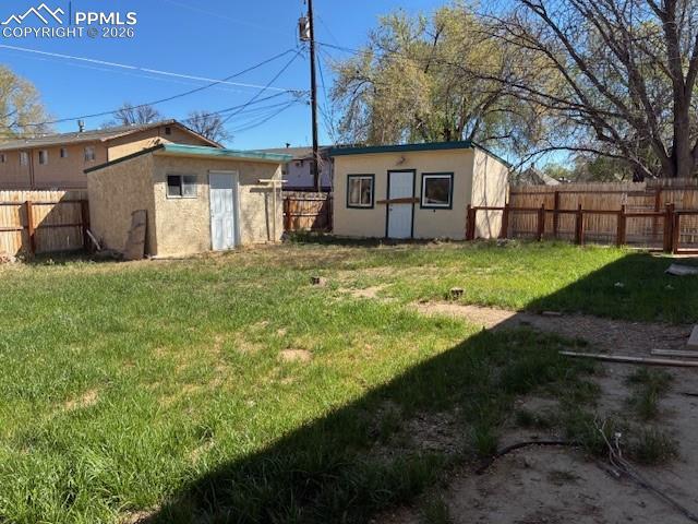 Image 23 of 24: Fenced backyard featuring an outbuilding