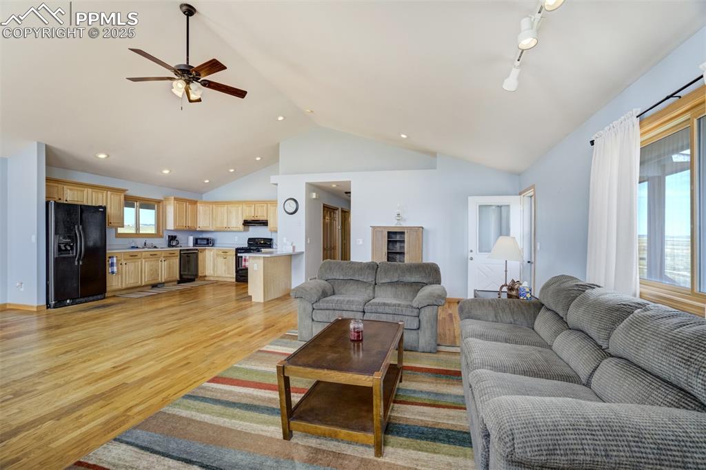 Image 17 of 50: Living room featuring ceiling fan, light wood finished floors, high vaulted