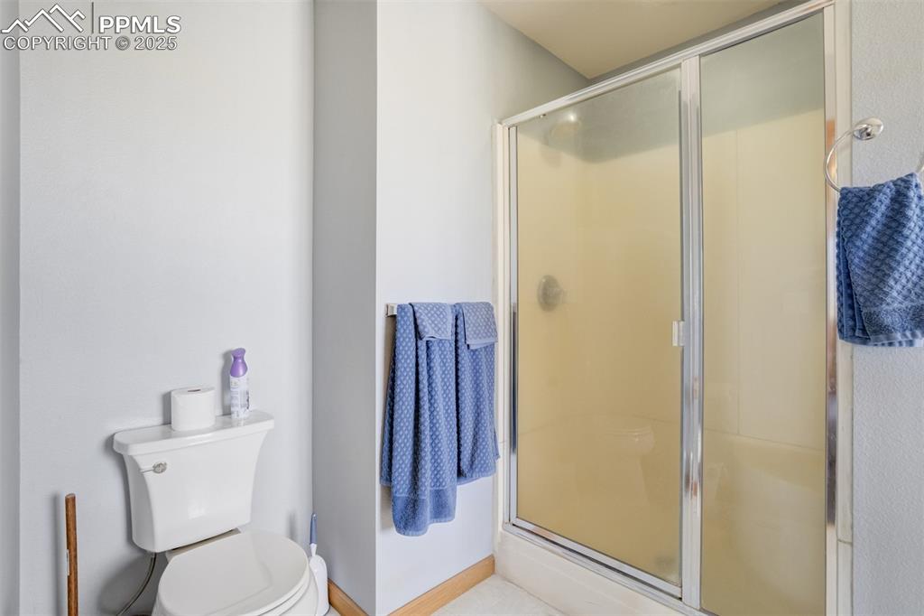 Image 30 of 50: Bathroom featuring toilet and a shower with shower door
