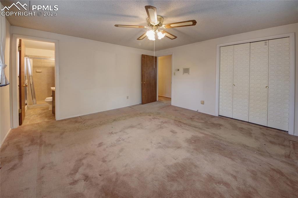 Image 17 of 37: Unfurnished bedroom featuring carpet, ceiling fan, ensuite bathroom, a clos