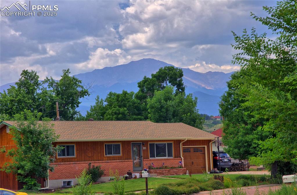 Image 2 of 37: View of front of house with a mountain view, a shingled roof, and an attach