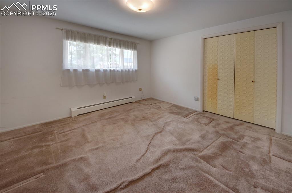 Image 20 of 37: Unfurnished bedroom with a baseboard heating unit, carpet flooring, and a c