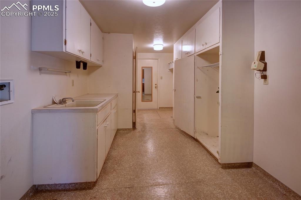 Image 28 of 37: Hallway with baseboards and a sink