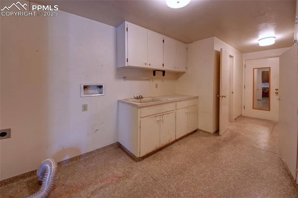Image 29 of 37: Washroom with hookup for an electric dryer, cabinet space, and hookup for a