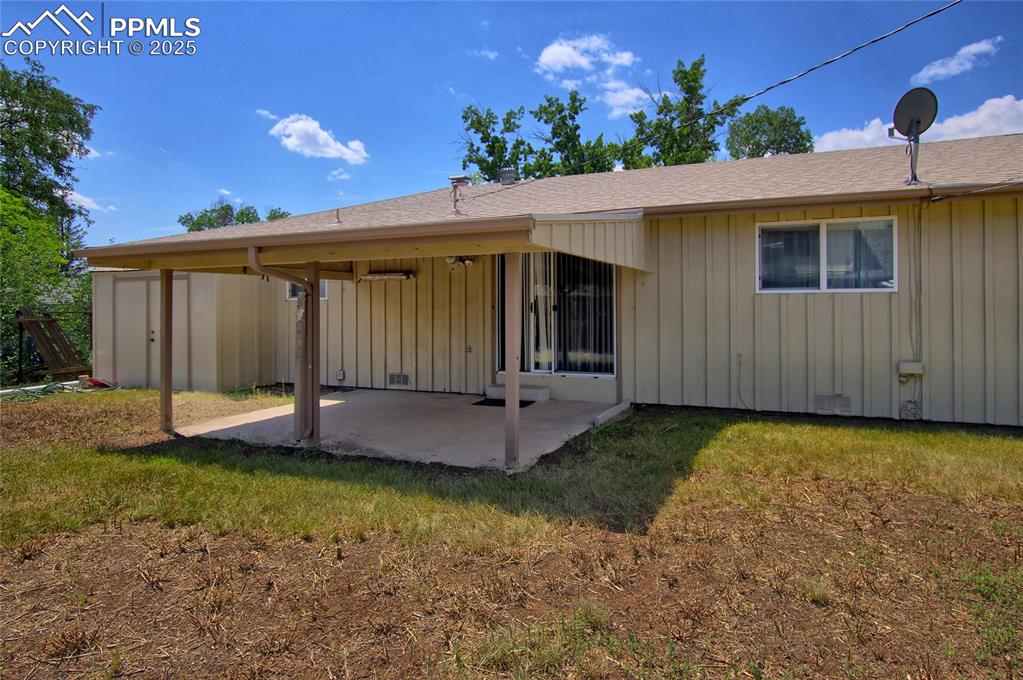 Image 35 of 37: Rear view of property with a patio area, board and batten siding, roof with