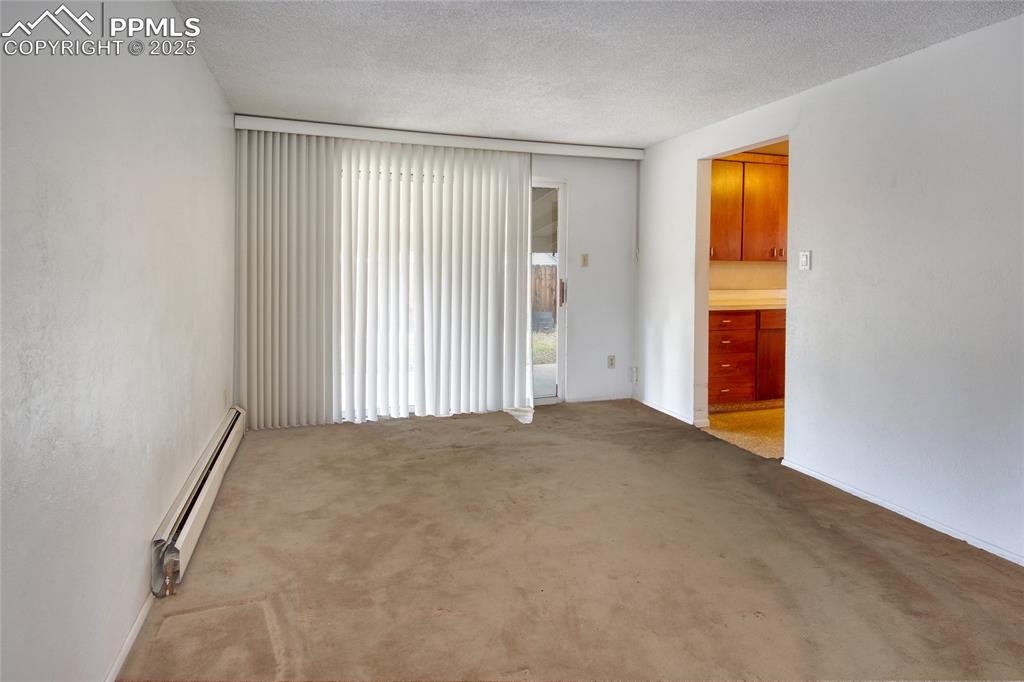 Image 7 of 37: Unfurnished room featuring a baseboard heating unit, light colored carpet,
