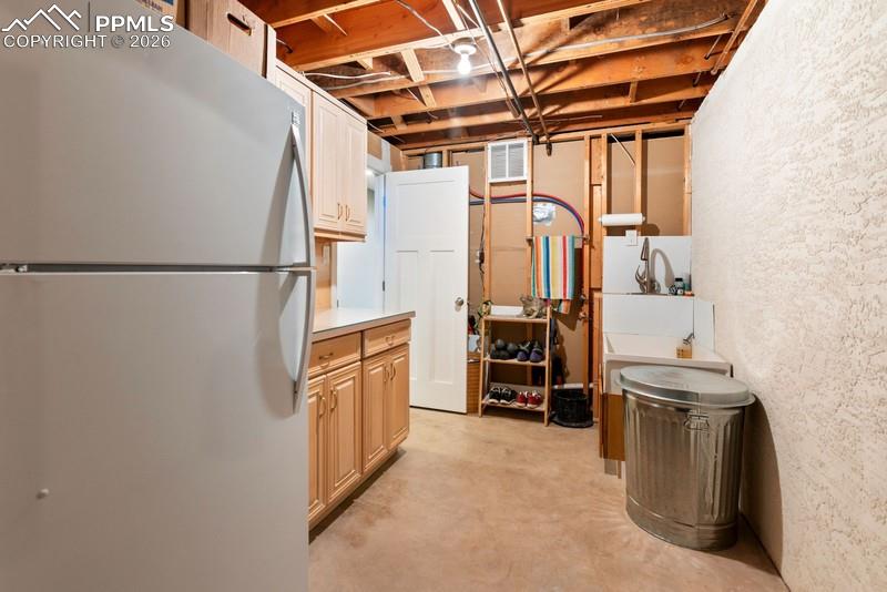 Image 39 of 47: Storage room with dog washing station and additional refrigerator included.