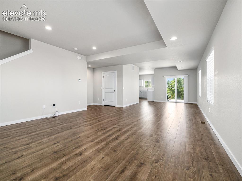 Image 15 of 30: Expansive living area featuring wood-finish flooring, recessed lighting, an
