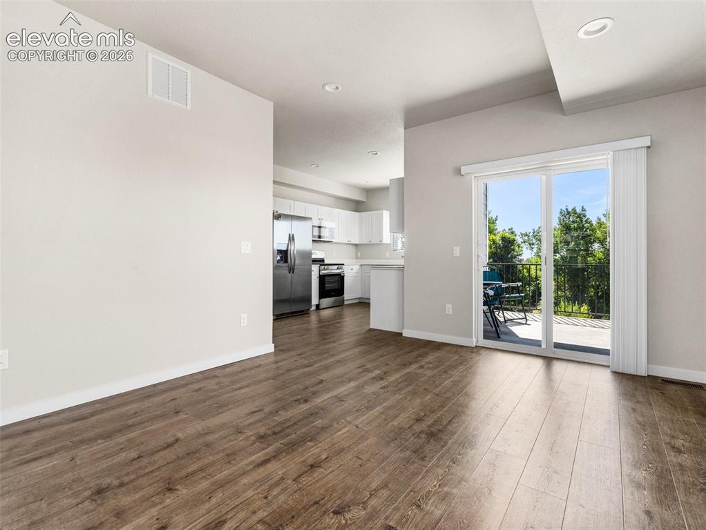 Image 17 of 30: Wood-finish flooring throughout, recessed lighting, and a sliding glass doo