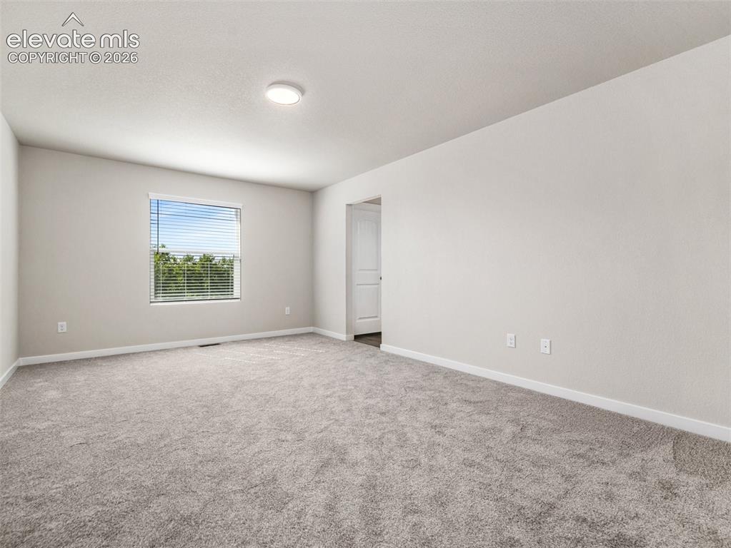 Image 9 of 30: Spacious room featuring neutral carpeting, light-toned walls, and a ceiling