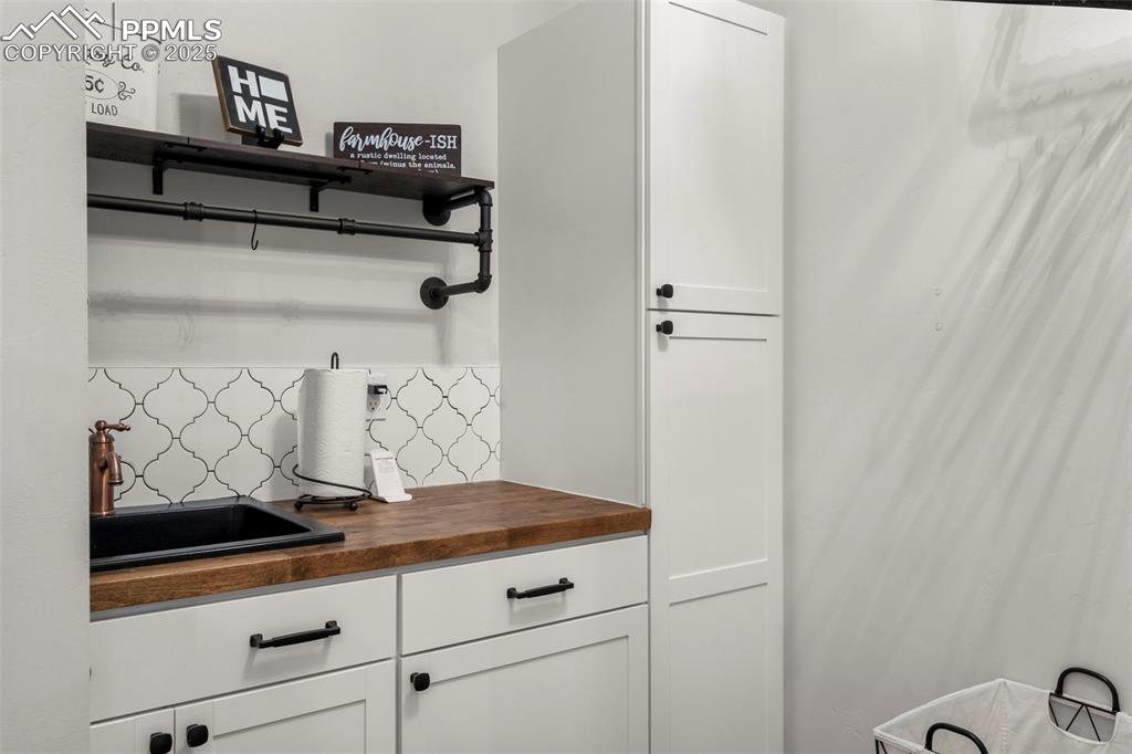 Image 18 of 50: Sink and lots of storage in the laundry room. 