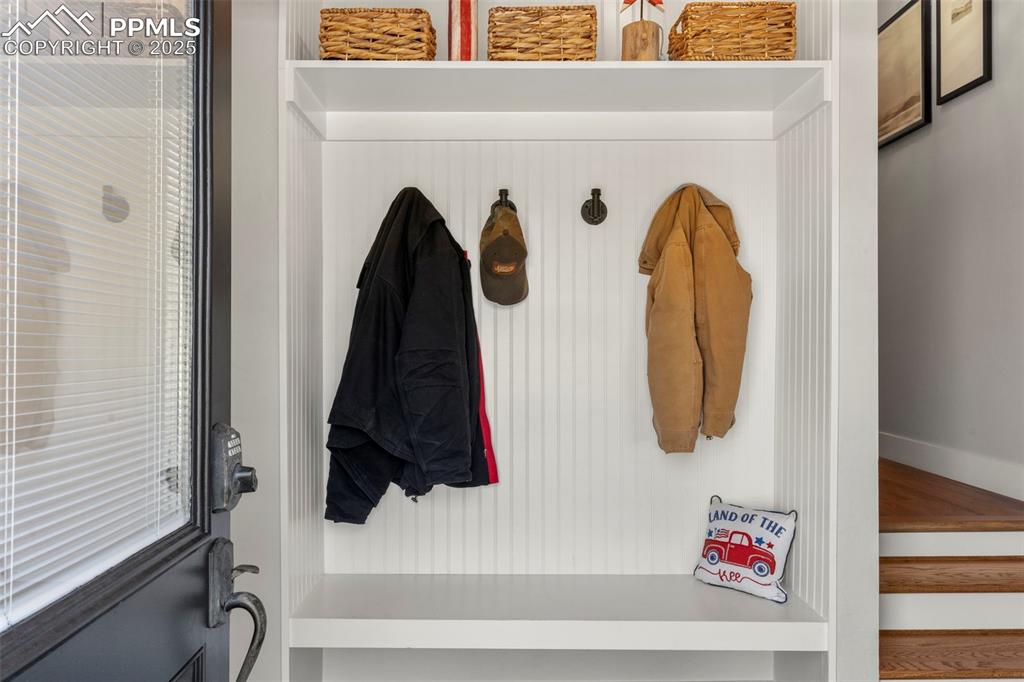 Image 19 of 50: Just off the garage is the mud room with bench and hooks for coats and bags