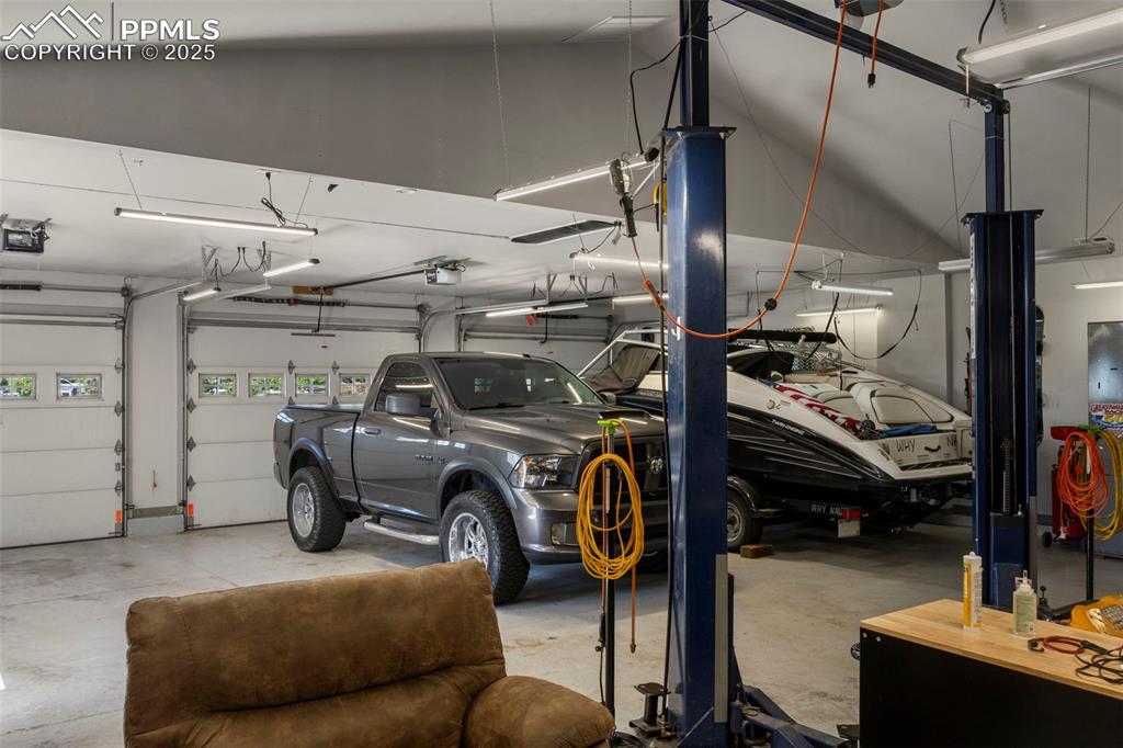 Image 40 of 50: Detached garage with car lift and air compressor.
