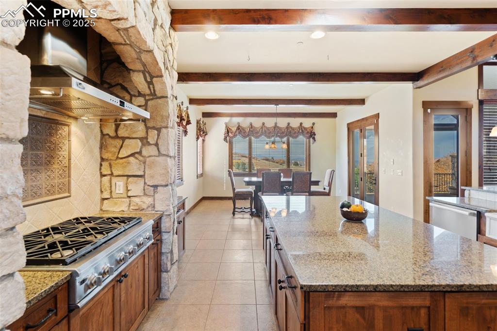 Image 13 of 50: The informal dining area provides access to the expansive upper level trex