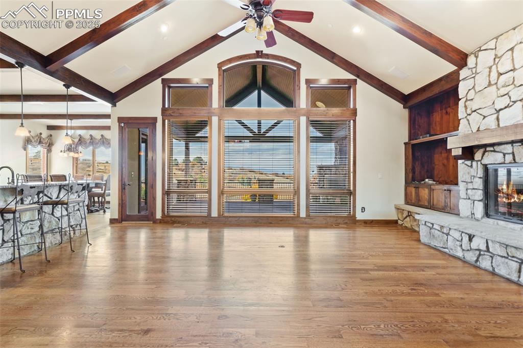 Image 14 of 50: The great room is appointed with a beautiful stone, gas fireplace, floor to