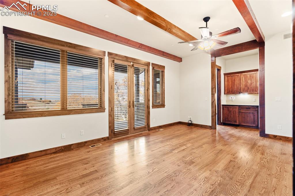 Image 21 of 50: French doors in the primary bedroom provide access to the main deck. The wi