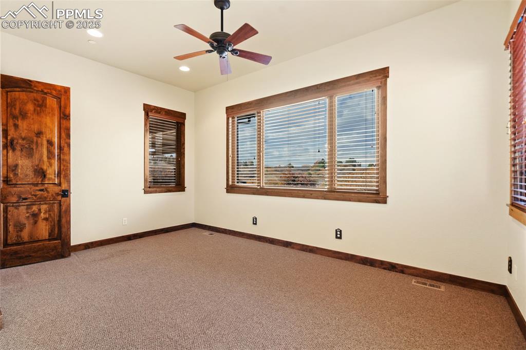 Image 24 of 50: This carpeted bonus room is adjacent to the primary bedroom. How will you