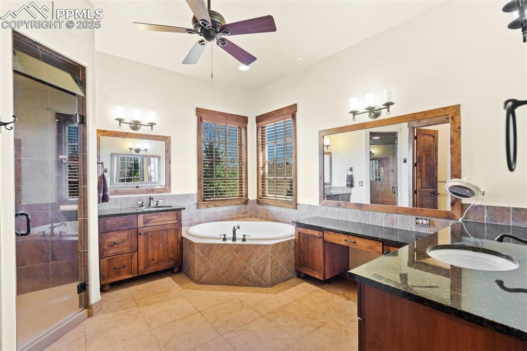 Image 26 of 50: The primary bath boasts 2 separate vanities, a dressing area, soaking tub,