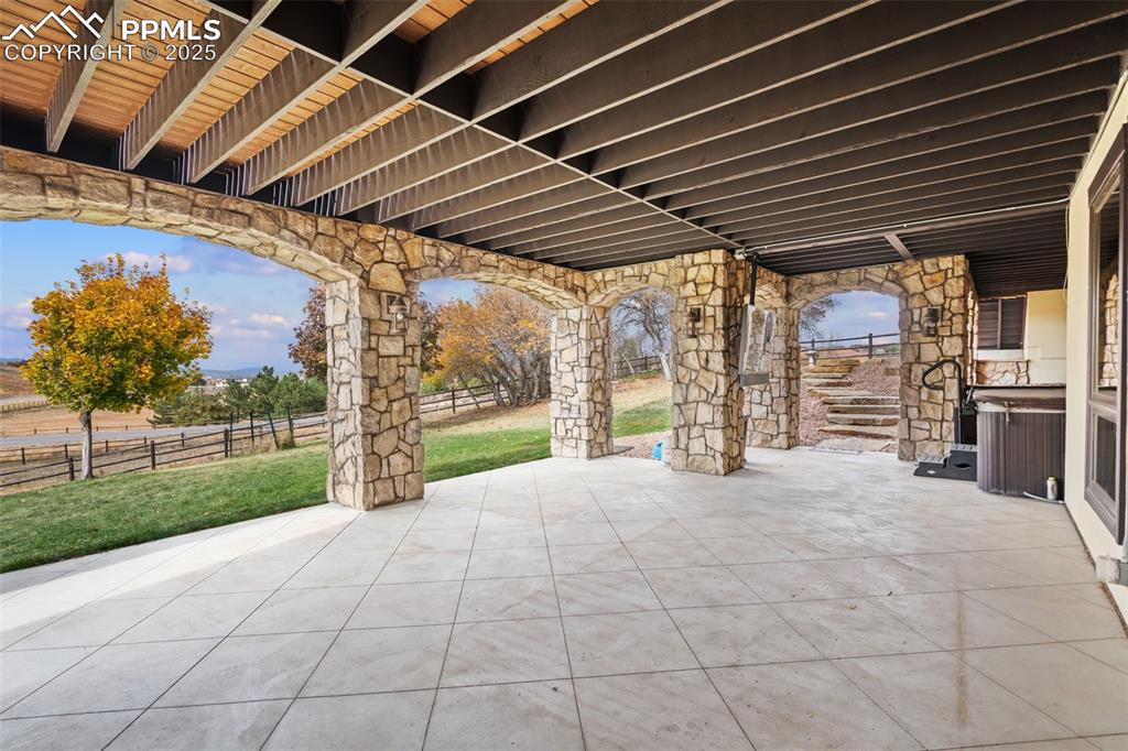 Image 39 of 50: This gorgeous, expansive lower patio, highlighted with stone arches, featur