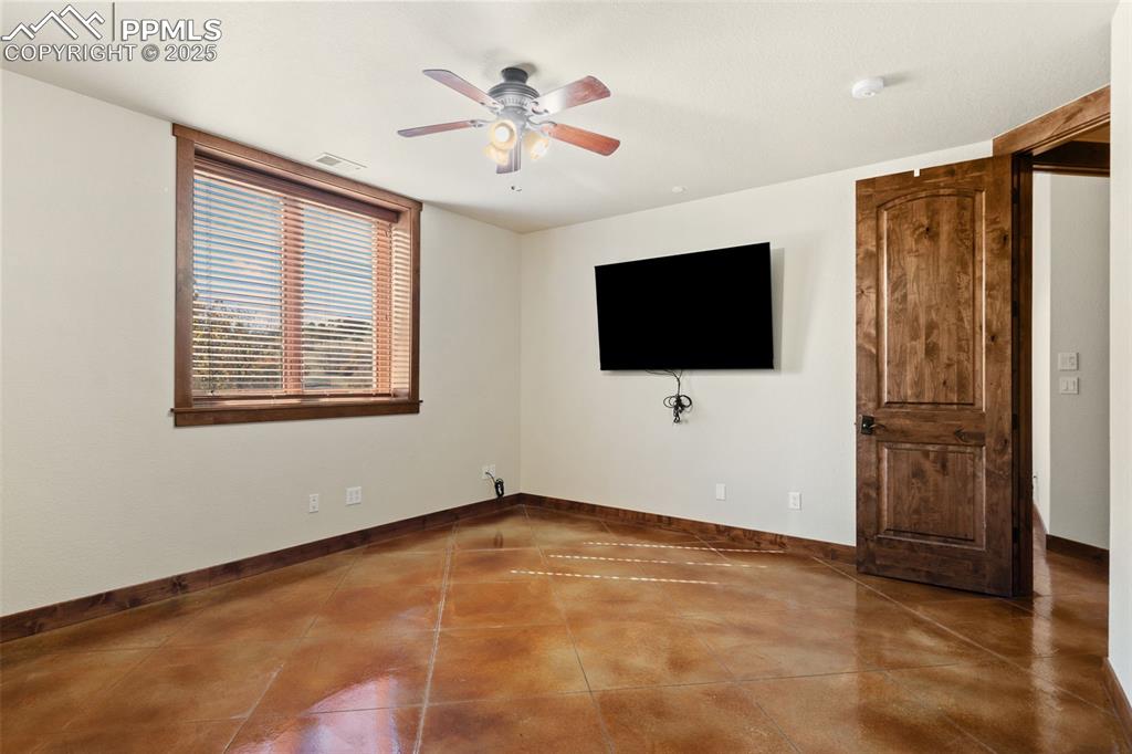 Image 45 of 50: Basement bedroom 5 features a walk-in closet and stained, stamped concrete