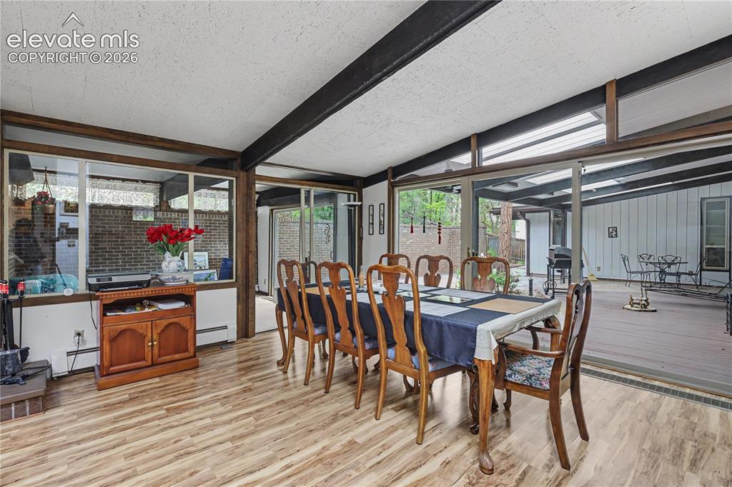 Image 17 of 50: Dining area featuring wood-finish flooring, exposed ceiling beams, and expa