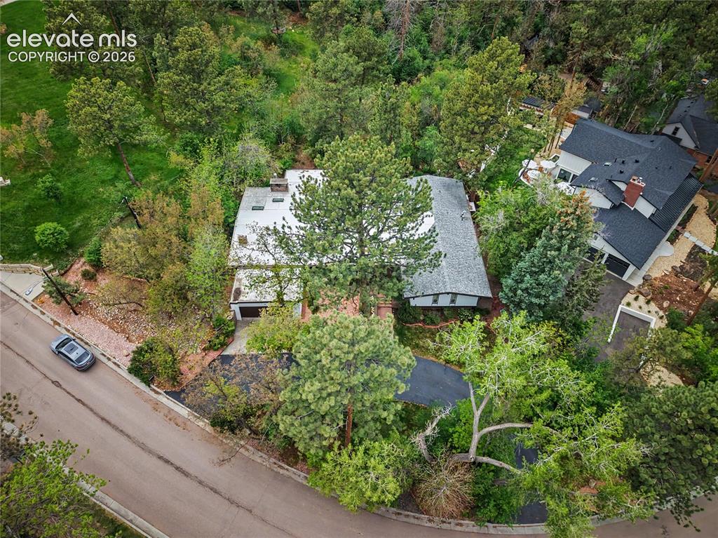 Image 2 of 50: Aerial view of a property surrounded by mature trees